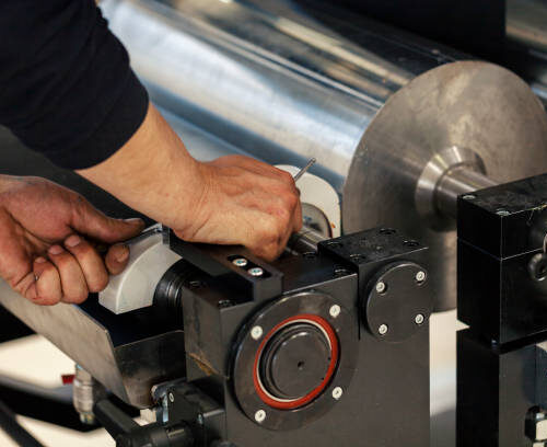 assembling metal parts on printing press, close up Flexographic drum repair onsite